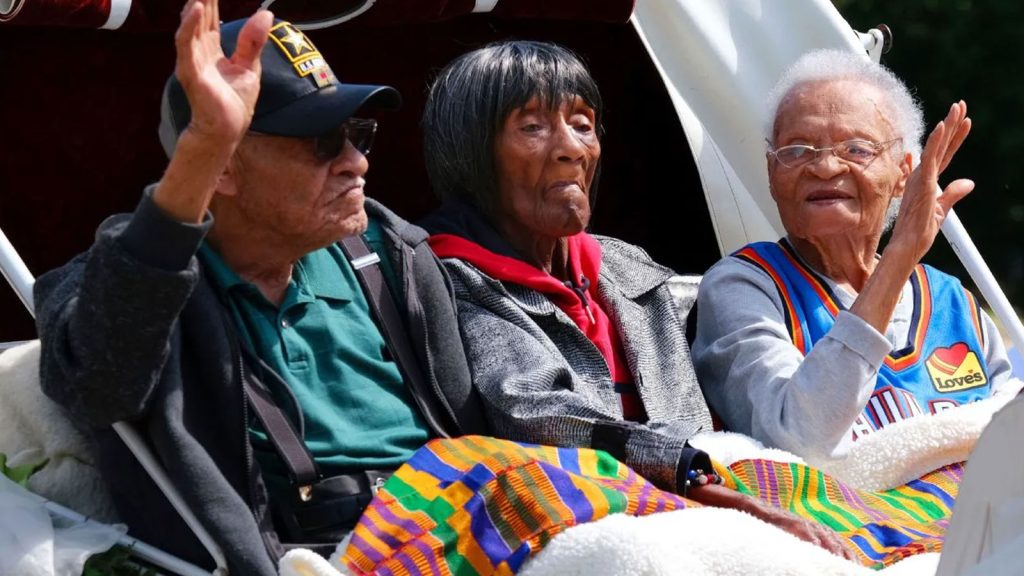Tulsa Race Massacre survivors, from left to right: Hughes Van Ellis, Lessie Randle and Viola Fletcher ride in a carriage at the front of the Black Wall Street Memorial on May 28, 2021.
