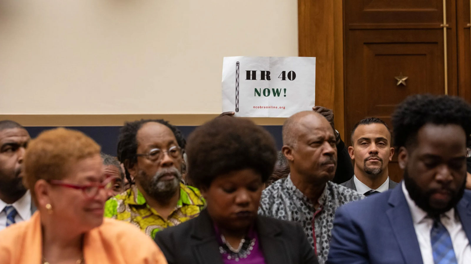 An attendee holds up a sign in support of HR 40, during the hearing on reparations for the descendants of slaves before the House Judiciary Subcommittee on the Constitution, Civil Rights and Civil Liberties, on Capitol Hill in Washington, D.C., on June 19, 2019. (