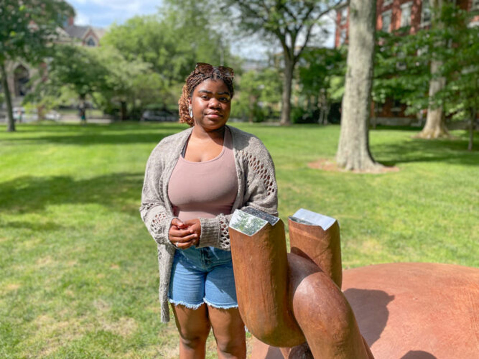 Gabrielle Brown stands next to a memorial at Brown University acknowledging that the school financially benefited from Rhode Island’s involvement in the slave trade. 
