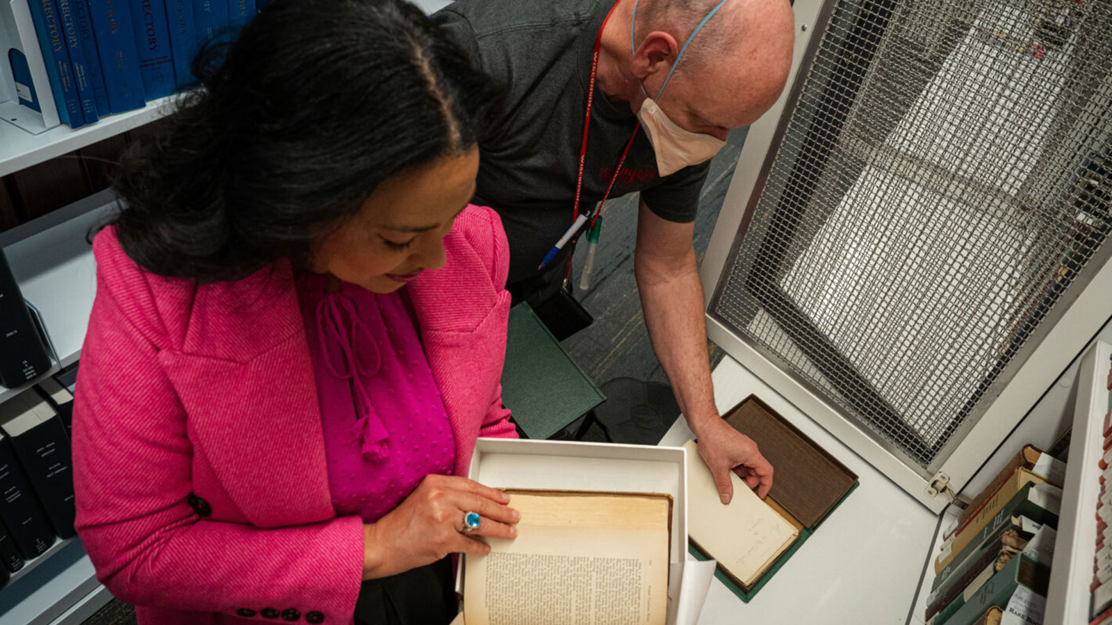 Dr. Karcheik Sims-Alvarado and librarian John Wright examine books about the history of Fulton County at the Central Library in downtown Atlanta.