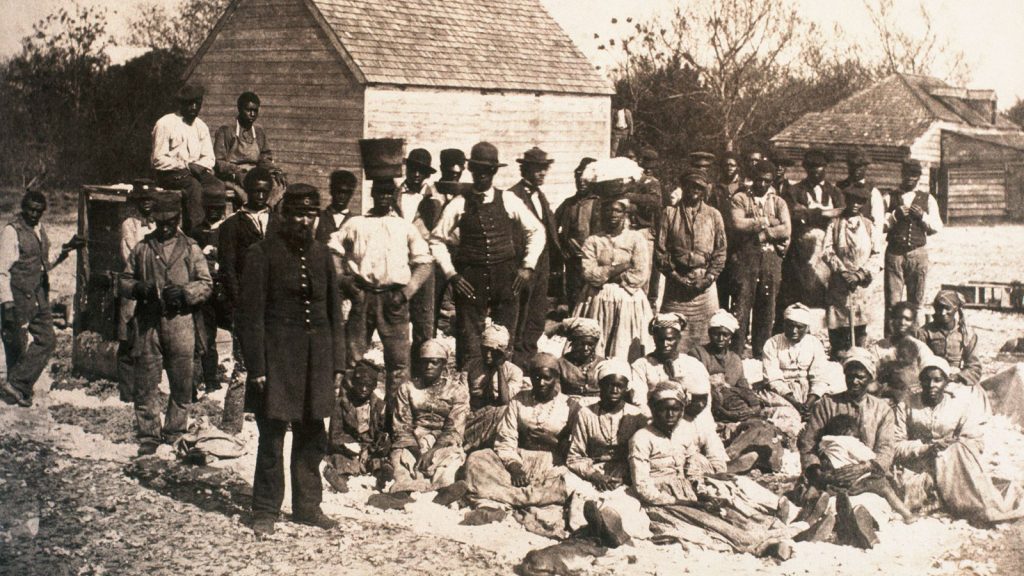 A group of formerly enslaved people gather on a South Carolina plantation during the Union occupation in 1862.